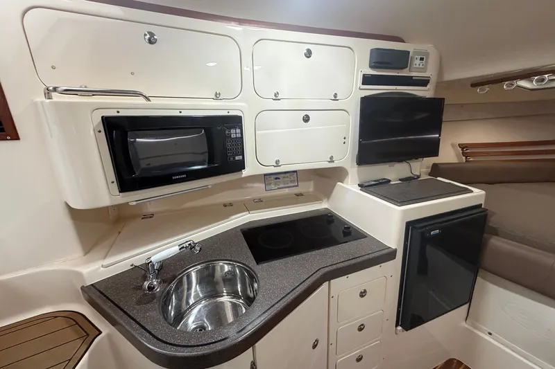  Yacht Photos Pics 2004 Grady-White Express 330 cabin kitchen with microwave, sink, and TV.