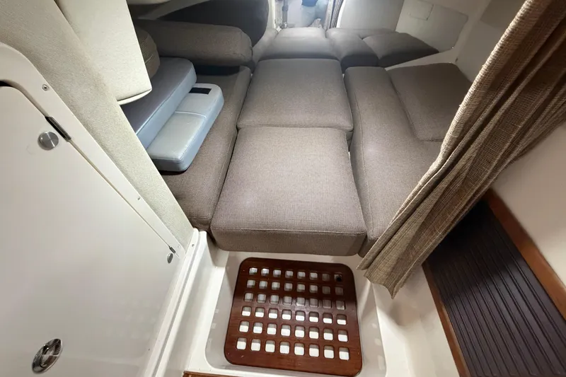  Yacht Photos Pics 2004 Grady-White Express 330 cabin interior with cushioned seating and wooden floor detail.