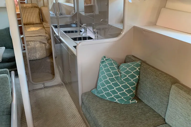 Jade Yacht Photos Pics Interior of a 1998 Magnum 50 Bestia yacht with cozy seating and modern kitchen area.