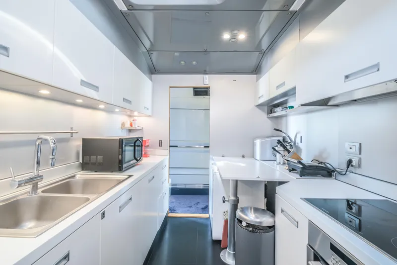 Eternity 44 Yacht Photos Pics Modern kitchen interior on 2010 Arcadia Yachts 85, featuring sleek white cabinetry and appliances.