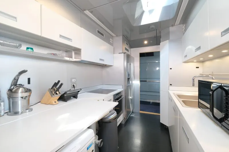 Eternity 44 Yacht Photos Pics Modern kitchen interior on 2010 Arcadia Yachts 85, featuring sleek white cabinetry and appliances.