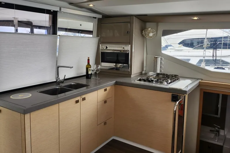  Yacht Photos Pics Modern kitchen interior of 2017 Fountaine Pajot Lucia 40 catamaran with appliances and window view.