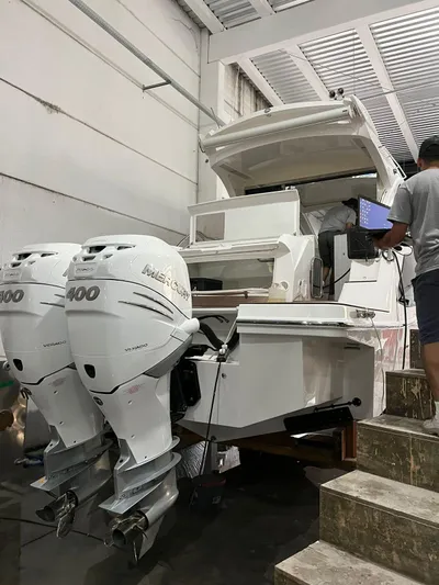 Elena Yacht Photos Pics 2023 Evolve 400HT boat with dual outboard motors in a workshop setting.