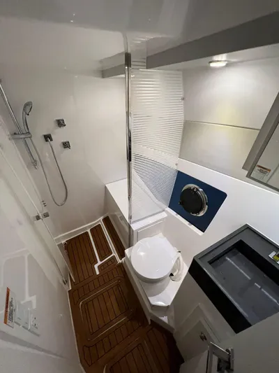 Elena Yacht Photos Pics Modern bathroom in 2023 Evolve 400HT yacht with shower, toilet, and wooden flooring.