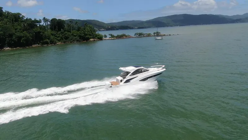 Elena Yacht Photos Pics 2023 Evolve 400HT yacht cruising on a scenic lake with lush green hills.
