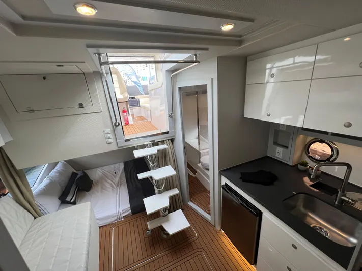 Elena Yacht Photos Pics 2023 Evolve 400HT yacht interior with modern kitchen, compact living space, and wooden flooring.