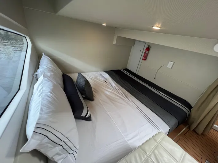 Elena Yacht Photos Pics Luxurious cabin interior of 2023 Evolve 400HT yacht with cozy bed and window view.