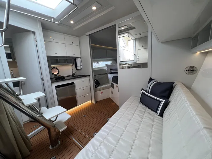 Elena Yacht Photos Pics Luxurious interior of 2023 Evolve 400HT yacht with modern kitchen and cozy seating area.