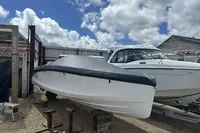 2023 Rand Source 22 boat covered and stored outdoors under a cloudy sky.