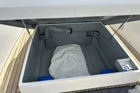 Open storage compartment on Rand Source 22 boat, featuring a hose and white cover, 2023 model.