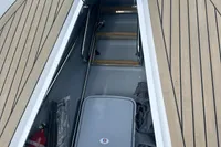2023 Rand Source 22 boat storage compartment with wooden deck and safety equipment.