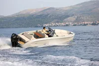 2023 Rand Source 22 boat cruising on open water with scenic mountain backdrop.