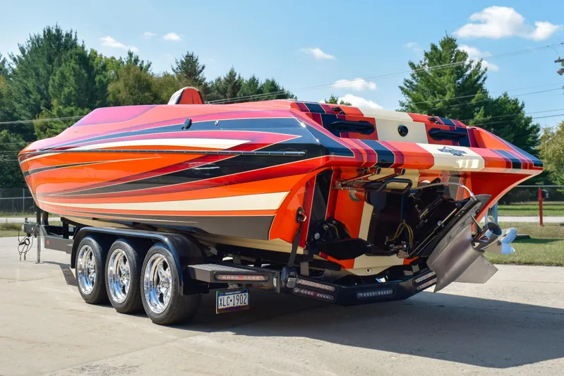 Yacht Photos Pics 2012 DCB 28 Extreme boat with vibrant orange and red design on a triple-axle trailer.