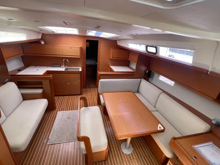Send Me Yacht Photos Pics Interior of 2018 Dufour 460 Grand Large yacht with elegant wood finish and seating area.