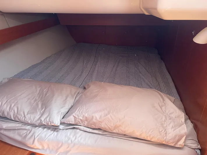 Send Me Yacht Photos Pics Cozy cabin bed in 2018 Dufour 460 Grand Large yacht, featuring striped bedding and pillows.