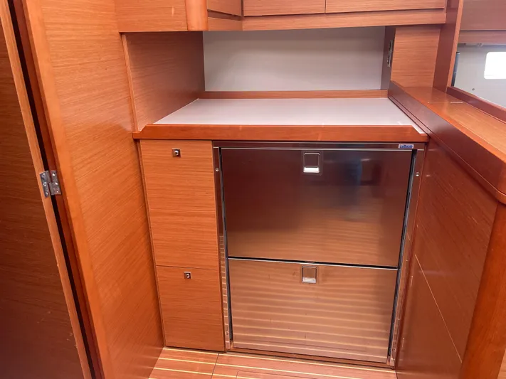 Send Me Yacht Photos Pics Wooden interior of 2018 Dufour 460 Grand Large yacht with stainless steel fridge.