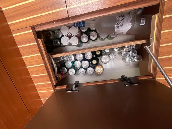 Send Me Yacht Photos Pics Storage compartment on 2018 Dufour 460 Grand Large yacht, filled with assorted beverage cans and bottles.