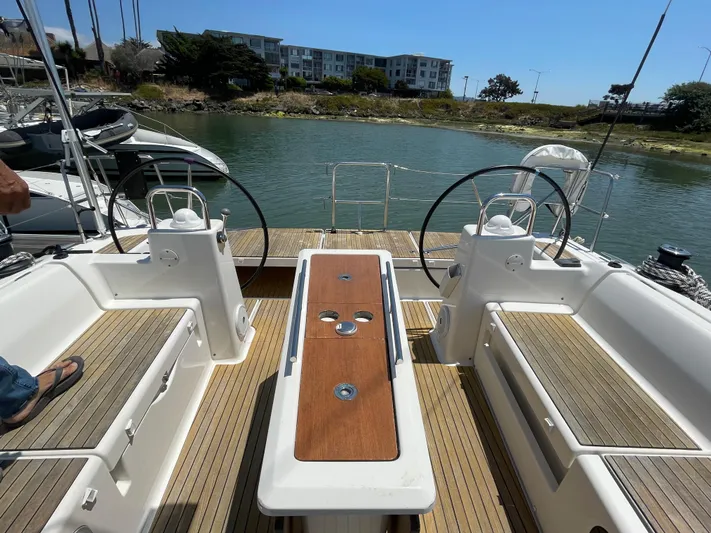Send Me Yacht Photos Pics Dufour 460 Grand Large 2018 yacht cockpit with dual steering wheels and wooden seating.
