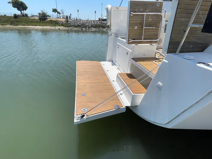 Send Me Yacht Photos Pics Dufour 460 Grand Large 2018 yacht with open swim platform on calm water.