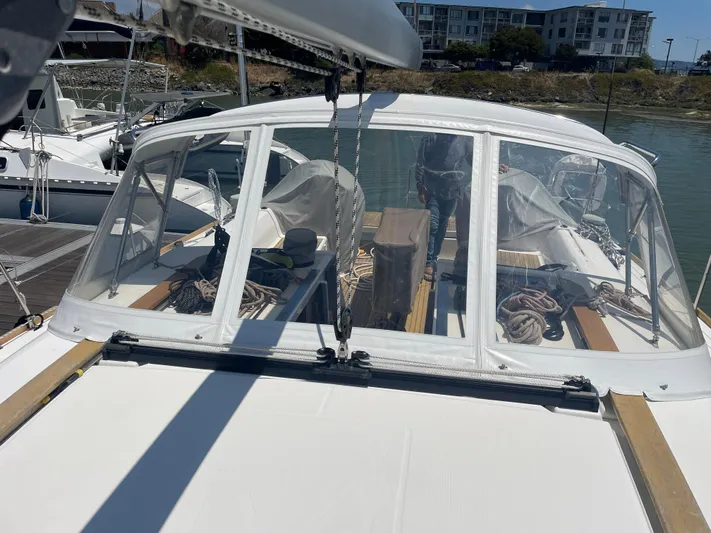 Send Me Yacht Photos Pics 2018 Dufour 460 Grand Large sailboat docked, featuring a covered cockpit and visible ropes.