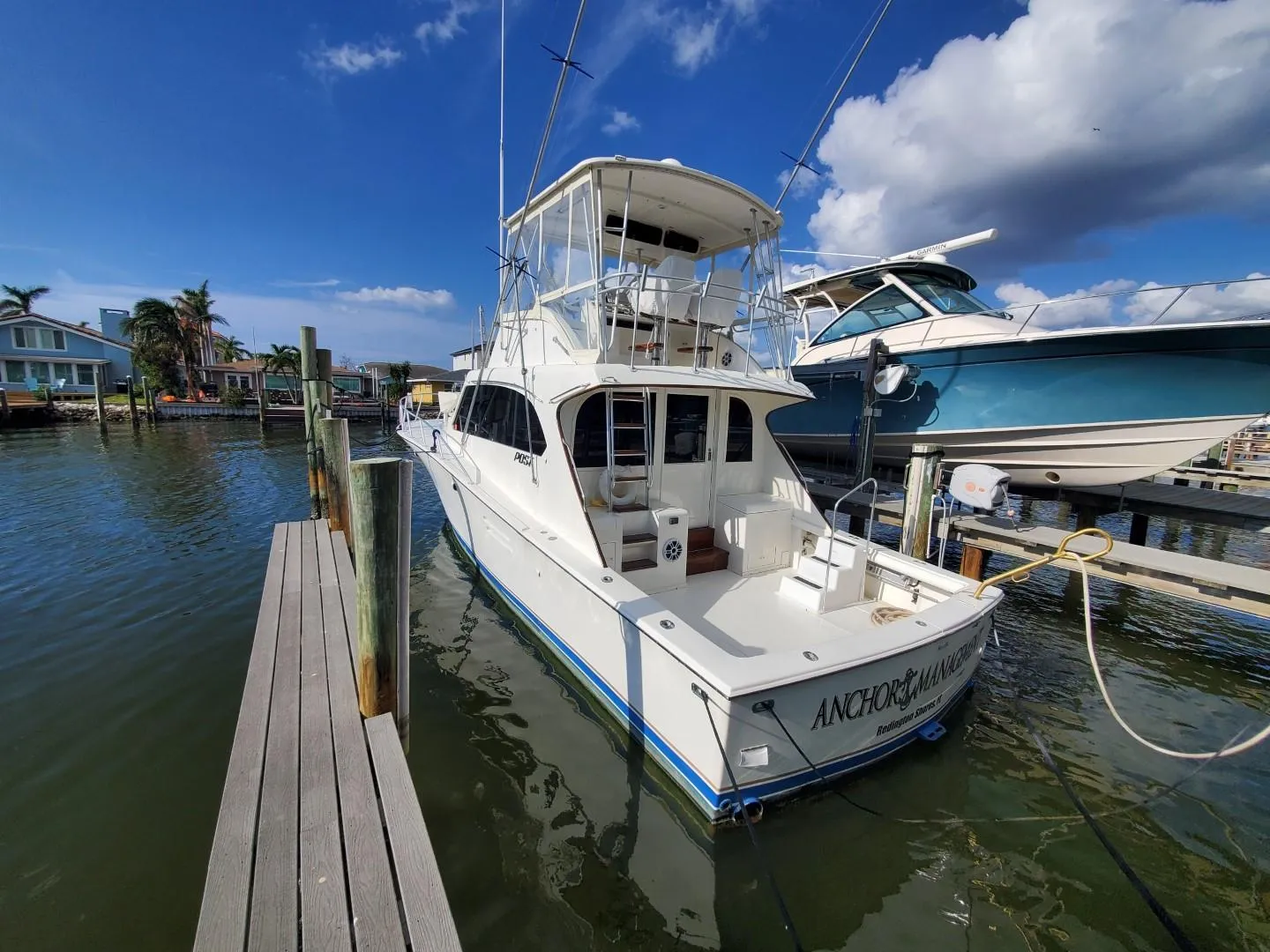 1988 Post 46 Sportfish boat docked at marina under clear blue sky.
