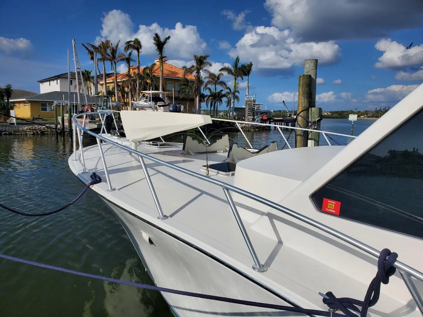 1988 Post 46 Sportfish boat docked by waterfront homes under a blue sky.