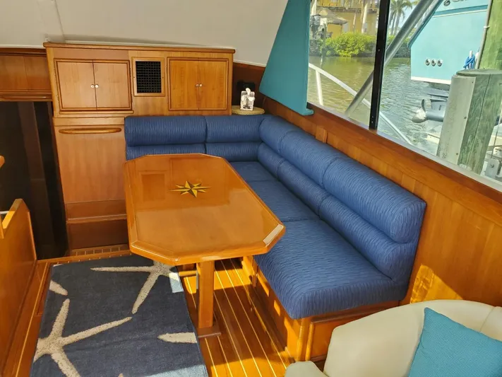 Anchor Management Yacht Photos Pics 1988 Post 46 Sportfish yacht interior with blue seating and wooden table.