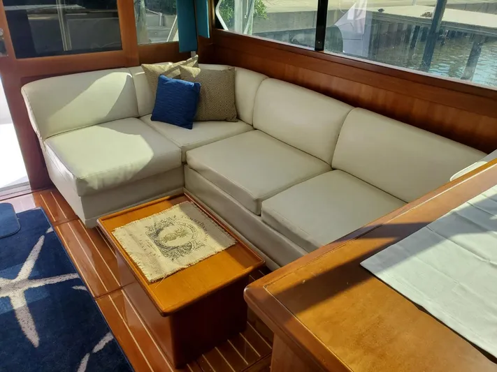 Anchor Management Yacht Photos Pics 1988 Post 46 Sportfish interior with white sofa, wooden table, and nautical decor.