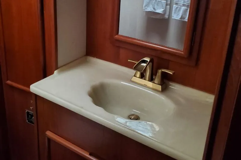 Anchor Management Yacht Photos Pics 1988 Post 46 Sportfish bathroom sink with wooden cabinetry and modern faucet.