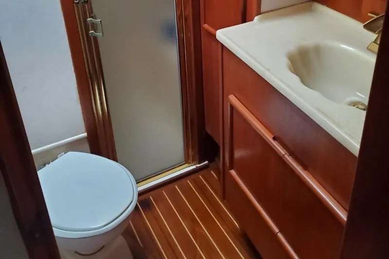Anchor Management Yacht Photos Pics 1988 Post 46 Sportfish bathroom with shower, toilet, and wooden cabinetry.