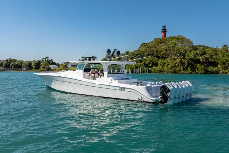  Yacht Photos Pics 2026 HCB 65 Estrella luxury yacht cruising near a scenic lighthouse and lush greenery.