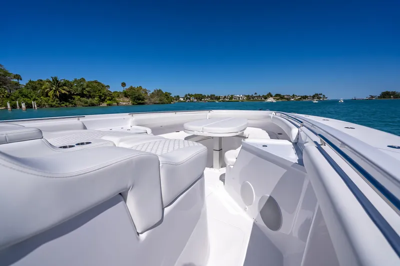  Yacht Photos Pics Luxurious 2026 HCB 65 Estrella boat interior with white seating, cruising on clear blue waters.