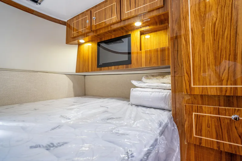  Yacht Photos Pics Luxurious cabin interior of 2026 HCB 65 Estrella with wood finish and cozy bedding.