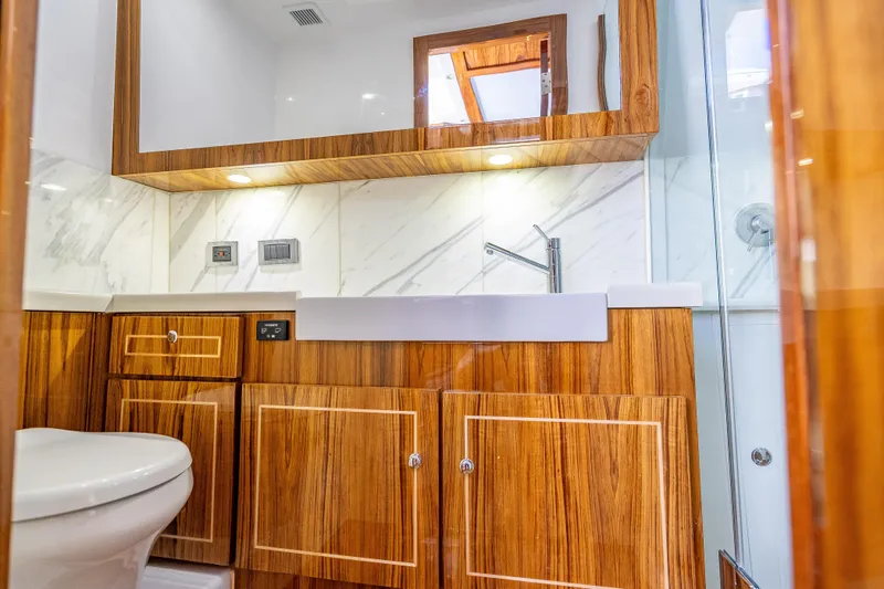  Yacht Photos Pics Luxurious bathroom interior of 2026 HCB 65 Estrella yacht with wood accents and modern fixtures.