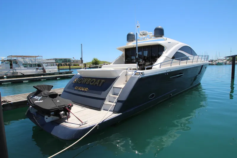  Yacht Photos Pics 2007 Uniesse 70 Sport yacht docked in a marina, featuring sleek design and jet ski.