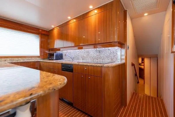 Chona Yacht Photos Pics Luxurious kitchen interior of 2007 Viking 64 Enclosed yacht with wood cabinetry and granite countertops.