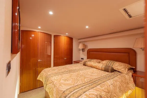 Chona Yacht Photos Pics Luxurious bedroom interior of 2007 Viking 64 Enclosed yacht with elegant wood finishes.