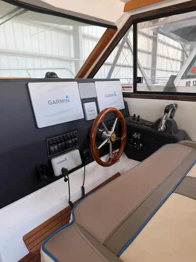  Yacht Photos Pics 2017 Cutwater C-302 Sport Coupe helm with Garmin navigation, wooden steering wheel, and control panel.