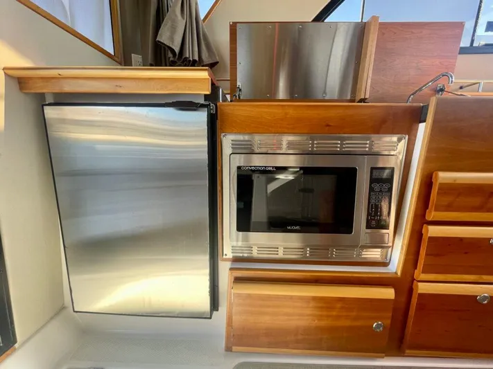  Yacht Photos Pics 2017 Cutwater C-302 Sport Coupe kitchen with stainless steel fridge and microwave.