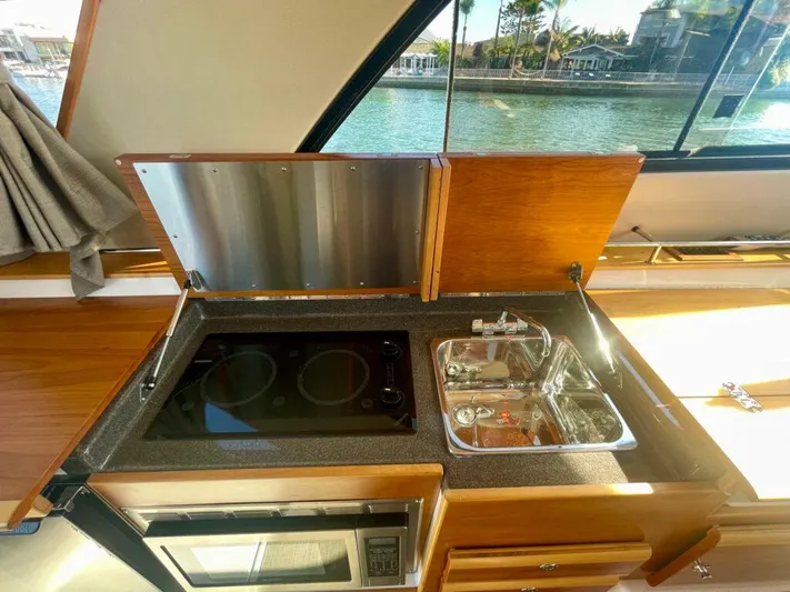  Yacht Photos Pics 2017 Cutwater C-302 Sport Coupe kitchen with stove, sink, and window view.