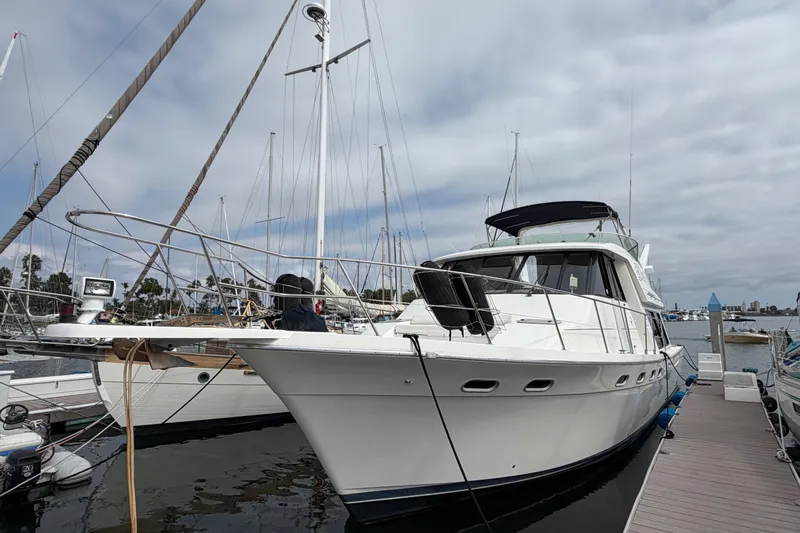 B Liner Yacht Photos Pics 1998 Bayliner 4788 Pilot House Motoryacht docked at marina under cloudy sky.