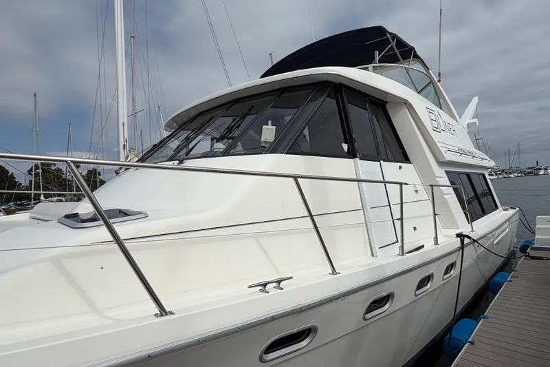 B Liner Yacht Photos Pics 1998 Bayliner 4788 Pilot House Motoryacht docked at marina, side view.