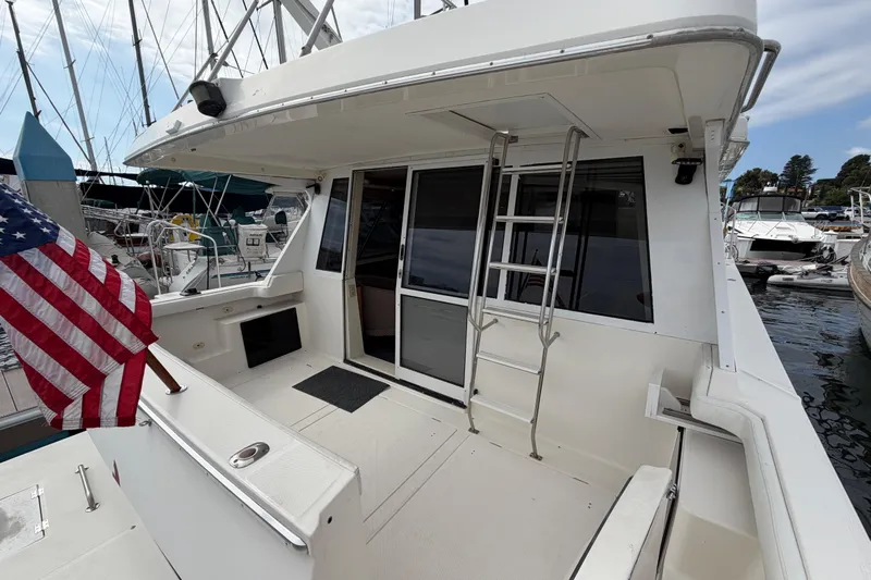 B Liner Yacht Photos Pics 1998 Bayliner 4788 Pilot House Motoryacht with American flag, docked at marina.