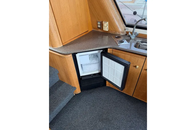 B Liner Yacht Photos Pics Interior of 1998 Bayliner 4788 yacht showing kitchenette with open mini fridge.