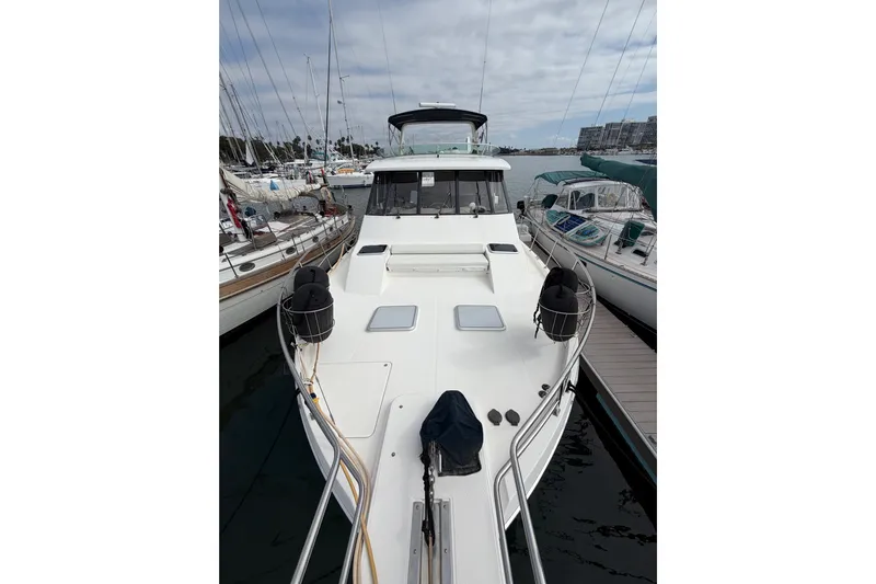 B Liner Yacht Photos Pics 1998 Bayliner 4788 Pilot House Motoryacht docked at marina, surrounded by sailboats.