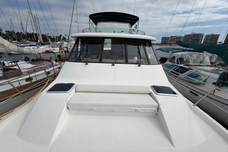 B Liner Yacht Photos Pics 1998 Bayliner 4788 Pilot House Motoryacht docked in a marina, surrounded by sailboats.