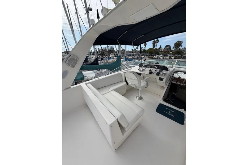 B Liner Yacht Photos Pics 1998 Bayliner 4788 Pilot House Motoryacht cockpit with seating and helm, docked at marina.