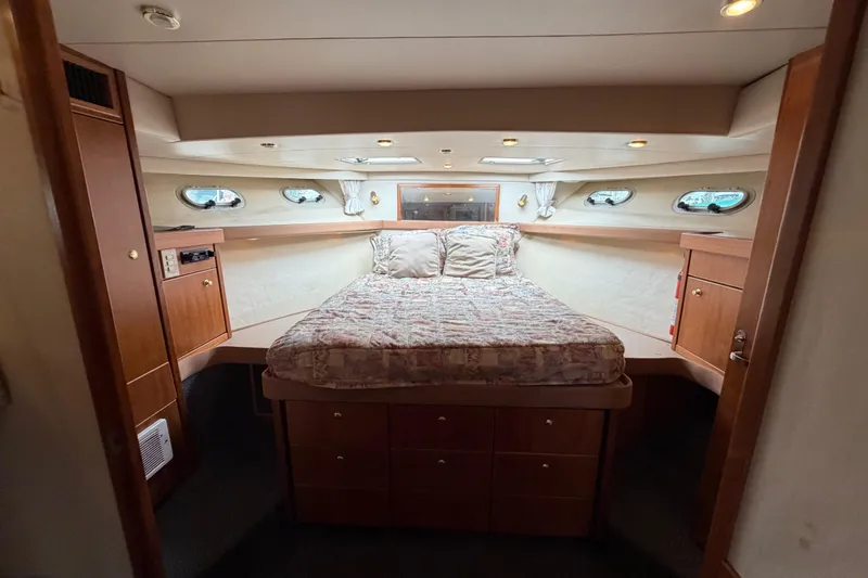 B Liner Yacht Photos Pics Luxurious bedroom interior of 1998 Bayliner 4788 Pilot House Motoryacht with cozy bed and wood cabinetry.