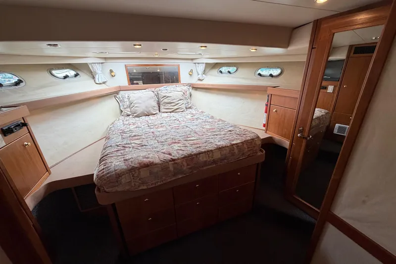 B Liner Yacht Photos Pics Luxurious bedroom in 1998 Bayliner 4788 Pilot House Motoryacht with cozy bed and wooden cabinetry.