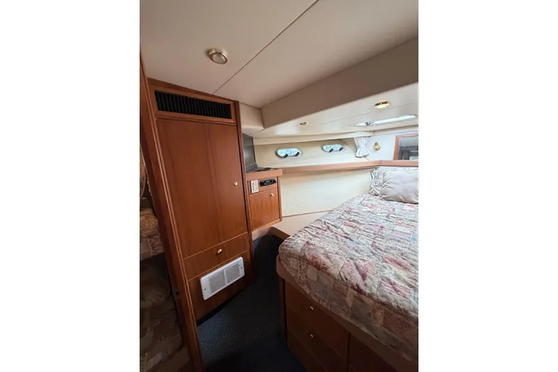 B Liner Yacht Photos Pics Interior of 1998 Bayliner 4788 Pilot House Motoryacht with cozy bedroom and wooden cabinetry.